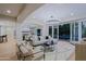 Bright living room with modern chandelier, stylish furniture, and seamless indoor-outdoor flow to pool at 18 W Kaler Dr, Phoenix, AZ 85021