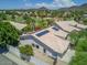 Aerial view of a community with well-maintained homes, golf course, palm trees and mountain views in the distance at 20906 N 56Th Dr, Glendale, AZ 85308