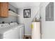 Functional laundry room with modern washer, dryer, water heater, and convenient shelving at 2121 W Union Hills Dr # 113, Phoenix, AZ 85027