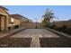 Paved backyard basketball court surrounded by rock landscaping and tall block wall for privacy at 2324 W Melody Dr, Phoenix, AZ 85041