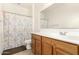 Standard bathroom features a vanity with wood cabinets, a toilet, and a tub/shower with floral curtain at 2324 W Melody Dr, Phoenix, AZ 85041