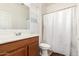 Bright bathroom with single vanity, toilet, shower with white curtain, and natural light from window at 2324 W Melody Dr, Phoenix, AZ 85041
