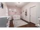 Bright Bedroom with pink walls features white crib, plush rug, and changing table for baby's comfort at 2324 W Melody Dr, Phoenix, AZ 85041