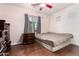Bedroom features hardwood floors, a window with gray curtains, and dark furniture at 2324 W Melody Dr, Phoenix, AZ 85041