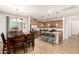 Modern kitchen with stainless steel appliances, granite countertops, island with bar stools, and dining area at 2324 W Melody Dr, Phoenix, AZ 85041