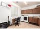 Spacious laundry room with tile floors, white washer and dryer, built-in cabinets, and a folding desk at 2324 W Melody Dr, Phoenix, AZ 85041