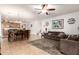 Open-concept living room and dining area featuring tile floors, ceiling fan, and sofas at 2324 W Melody Dr, Phoenix, AZ 85041