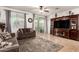 Spacious living room featuring tile floors, two sofas, large TV, and sliding door to backyard at 2324 W Melody Dr, Phoenix, AZ 85041