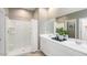 Bright bathroom featuring double sinks, a large mirror, and a shower with white tile at 23362 W Atlanta Ave, Buckeye, AZ 85326