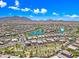 Aerial view of a Primary-planned community with a scenic lake, lush landscaping, and mountain views in the distance at 2387 E Runaway Bay Pl, Gilbert, AZ 85298