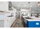 Open kitchen with white cabinets, a central island, stainless steel appliances, and wood-look floors at 2387 E Runaway Bay Pl, Gilbert, AZ 85298