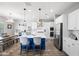 Modern kitchen featuring white cabinets, a blue island with seating, and stainless steel appliances at 2387 E Runaway Bay Pl, Gilbert, AZ 85298