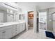 Bright main bathroom with dual sink vanity, white tile floors, and a walk-in shower at 2387 E Runaway Bay Pl, Gilbert, AZ 85298