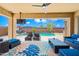 Covered outdoor patio featuring a ceiling fan, television, and furniture overlooking a pool at 2387 E Runaway Bay Pl, Gilbert, AZ 85298