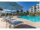 Resort-style pool with lounge chairs, umbrellas, and palm trees, offering a luxurious outdoor experience at 2511 W Queen Creek Rd # 174, Chandler, AZ 85248