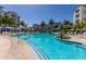 Large community pool with palm trees, lounge chairs, and landscaped grounds, perfect for outdoor relaxation at 2511 W Queen Creek Rd # 174, Chandler, AZ 85248
