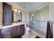 Bathroom featuring a glass-enclosed shower, dark wood vanity, and neutral tile flooring at 2524 S El Paradiso Dr # 82, Mesa, AZ 85202