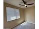 Neutral bedroom with carpeted floor, a ceiling fan and a window for natural light at 26449 N 84Th Dr, Peoria, AZ 85383