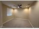 Cozy bedroom features neutral carpet, window, and ceiling fan at 26449 N 84Th Dr, Peoria, AZ 85383
