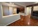 Open-concept living room with hardwood floors, stone fireplace, and open view to the kitchen at 26449 N 84Th Dr, Peoria, AZ 85383