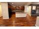 Spacious living room with hardwood floors and a stone fireplace, open to the kitchen at 26449 N 84Th Dr, Peoria, AZ 85383