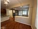 View from the kitchen to the living room with the stone fireplace and hardwood floors at 26449 N 84Th Dr, Peoria, AZ 85383
