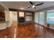 Cozy living room featuring a stone fireplace, hardwood floors, and access to the backyard at 26449 N 84Th Dr, Peoria, AZ 85383