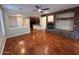 Open-concept living room featuring hardwood floors, stone fireplace, and seamless flow to the kitchen at 26449 N 84Th Dr, Peoria, AZ 85383