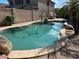 Backyard pool with rock features, stone coping, and mature landscaping at 26449 N 84Th Dr, Peoria, AZ 85383