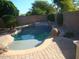 Backyard featuring a swimming pool with stone features, and a surrounding brick patio at 26449 N 84Th Dr, Peoria, AZ 85383