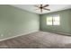 Bright bedroom featuring plush carpet, a ceiling fan, and a large window with natural light at 3235 E Camelback Rd # 124, Phoenix, AZ 85018