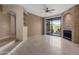 Open-concept living room with large sliding glass doors, a ceiling fan, and a stone fireplace at 3235 E Camelback Rd # 124, Phoenix, AZ 85018