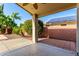 Covered back patio boasts a ceiling fan, brick accent wall, and access to a lush backyard at 4214 W Marco Polo Rd, Glendale, AZ 85308