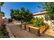 Lush backyard area featuring planter boxes, a mature tree, and desert landscaping at 4214 W Marco Polo Rd, Glendale, AZ 85308
