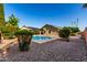A beautiful backyard featuring a pool, gravel landscaping, desert foliage, and solar panels at 4214 W Marco Polo Rd, Glendale, AZ 85308