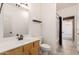 Bright bathroom with a wood vanity, sink, and toilet at 4214 W Marco Polo Rd, Glendale, AZ 85308