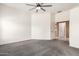 Spacious bedroom with carpet floors, a ceiling fan, and an attached bathroom at 4214 W Marco Polo Rd, Glendale, AZ 85308