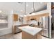 Well-lit kitchen with stainless steel appliances, central island with white countertop and window view at 4214 W Marco Polo Rd, Glendale, AZ 85308