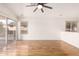 Bright living room features a ceiling fan, wood floors, and large sliding glass door to the exterior at 4214 W Marco Polo Rd, Glendale, AZ 85308