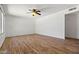 Spacious living room with wood-like floors, a ceiling fan, and a brick accent wall at 4346 W Mescal St, Glendale, AZ 85304