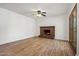 Bright living room featuring a brick fireplace and wood-look flooring at 4346 W Mescal St, Glendale, AZ 85304