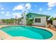 Backyard pool with blue tile trim surrounded by concrete and a white brick house with chimney on a sunny day at 4346 W Mescal St, Glendale, AZ 85304