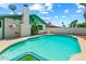 Backyard pool surrounded by concrete with blue tile trim, white brick house, and a chimney on a sunny day at 4346 W Mescal St, Glendale, AZ 85304