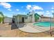 Backyard pool with a diving board, patio, shed, and an outdoor hangout spot surrounded by a fence at 4346 W Mescal St, Glendale, AZ 85304
