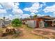 A backyard featuring a patio area, grass, and a storage shed at 4438 W Hatcher Rd, Glendale, AZ 85302