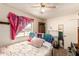 A bedroom featuring a ceiling fan, window, and personal items at 4438 W Hatcher Rd, Glendale, AZ 85302