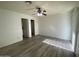 Spacious bedroom with a ceiling fan, hard surface flooring, and access to a bathroom for convenience at 4820 N 89Th Ave # 88, Phoenix, AZ 85037