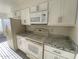 Well-lit kitchen boasts granite countertops, stainless steel appliances, and sleek white cabinetry at 4820 N 89Th Ave # 88, Phoenix, AZ 85037