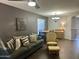 Comfortable living room with wood flooring, sofa with pillows, and a view into the dining area at 491 E Jeanne Ln, San Tan Valley, AZ 85140