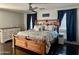 Comfortable bedroom with a rustic wooden bed, dark curtains, and neutral colors for a relaxing retreat at 491 E Jeanne Ln, San Tan Valley, AZ 85140